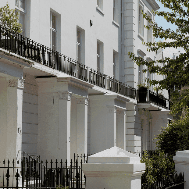Elegant white London townhouses with black wrought-iron fencing.