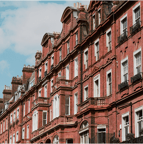 Red-brick Victorian terrace houses in a residential London street with classic architecture.